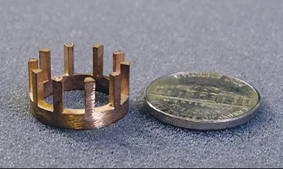 Berrylium Copper Casting part next to a nickel 